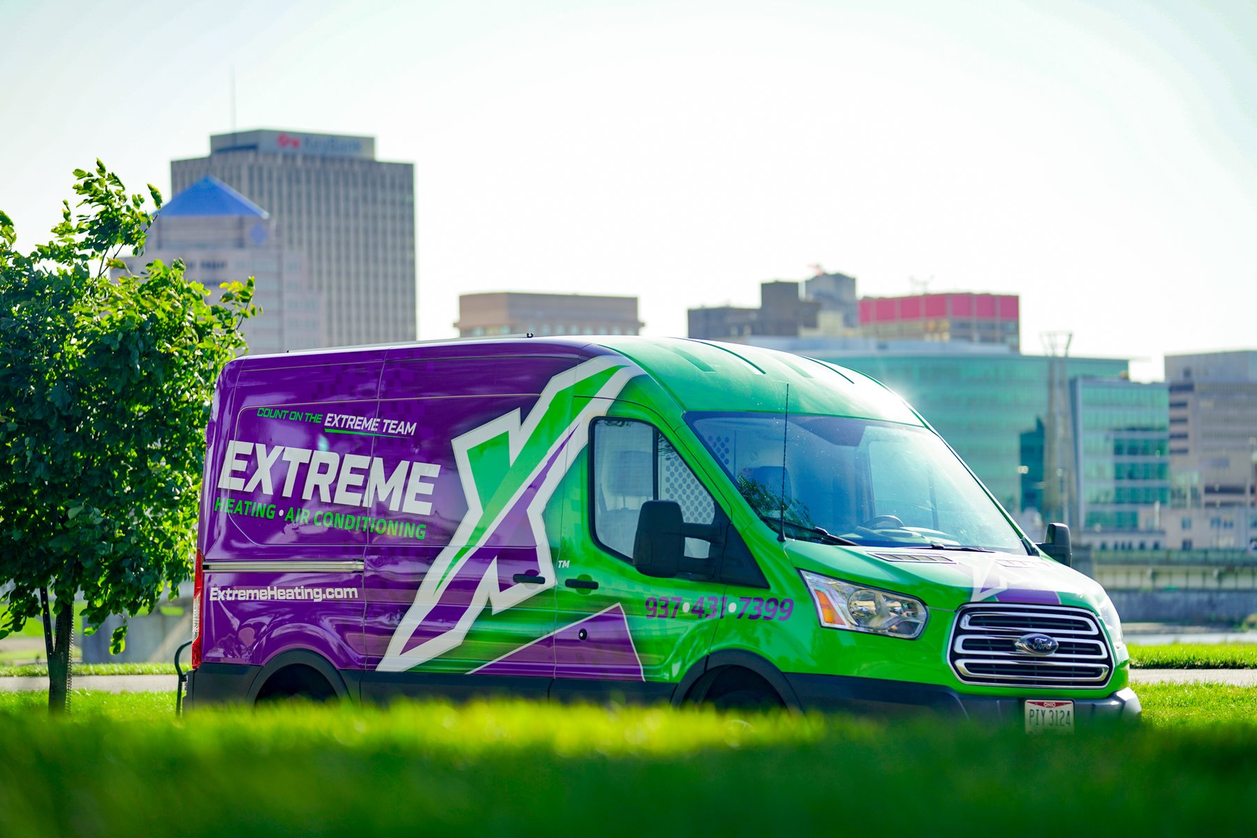 An Extreme Heating, Air, Plumbing service van with the Dayton skyline behind it