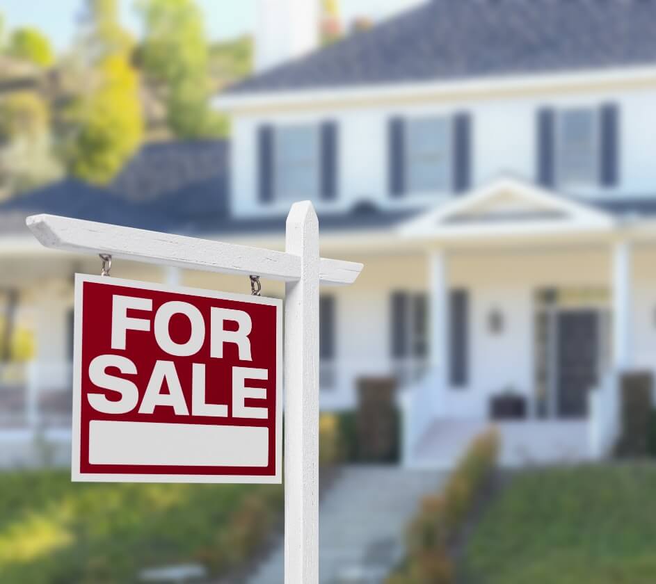 A for-sale sign in the front yard of a two-story house